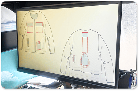 服のデザイン画をモニターで確認している様子