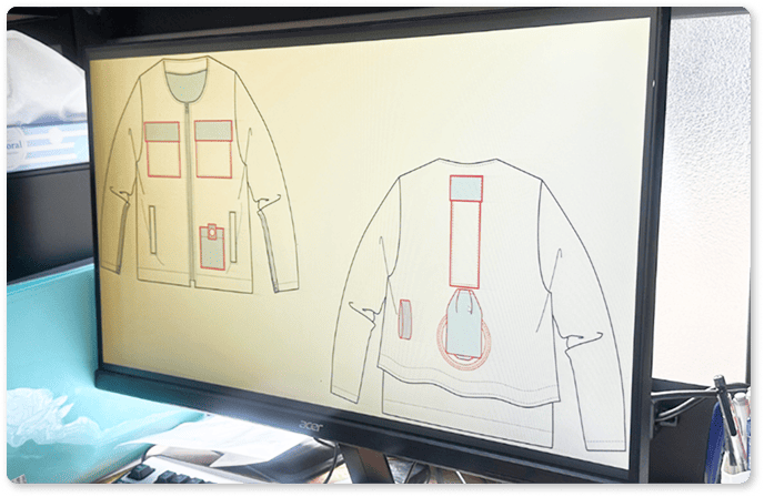 服のデザイン画をモニターで確認している様子